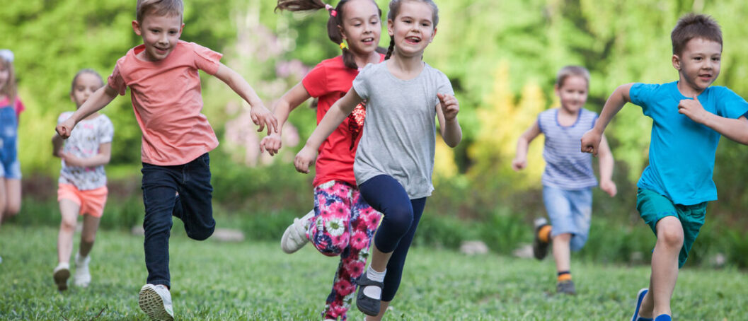 A group of happy children of boys and girls run in the Park on t