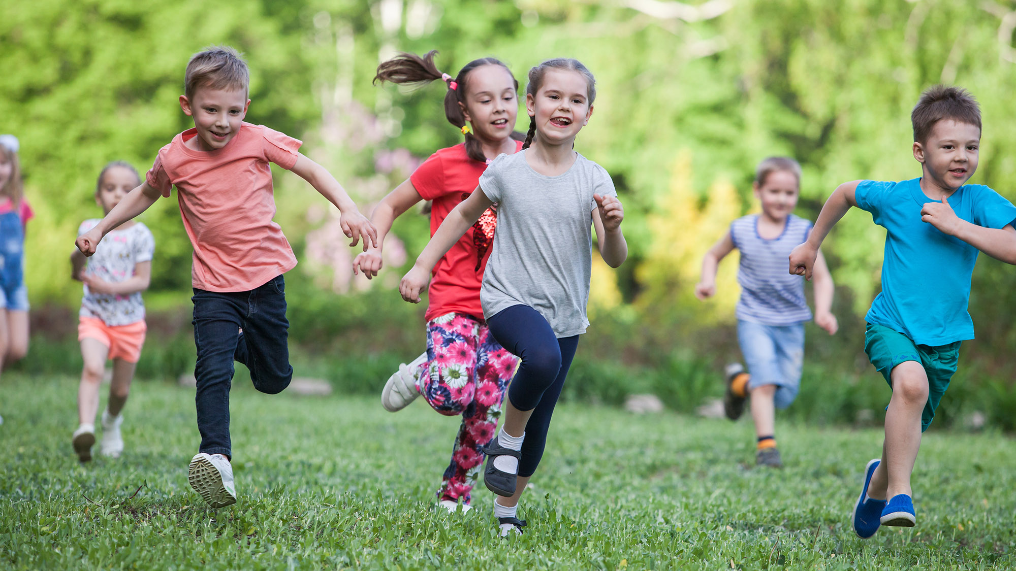 A group of happy children of boys and girls run in the Park on t